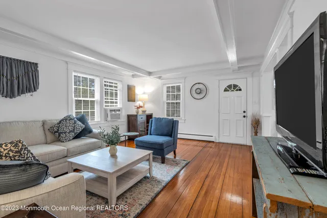 a living room with furniture a flat screen tv and a window