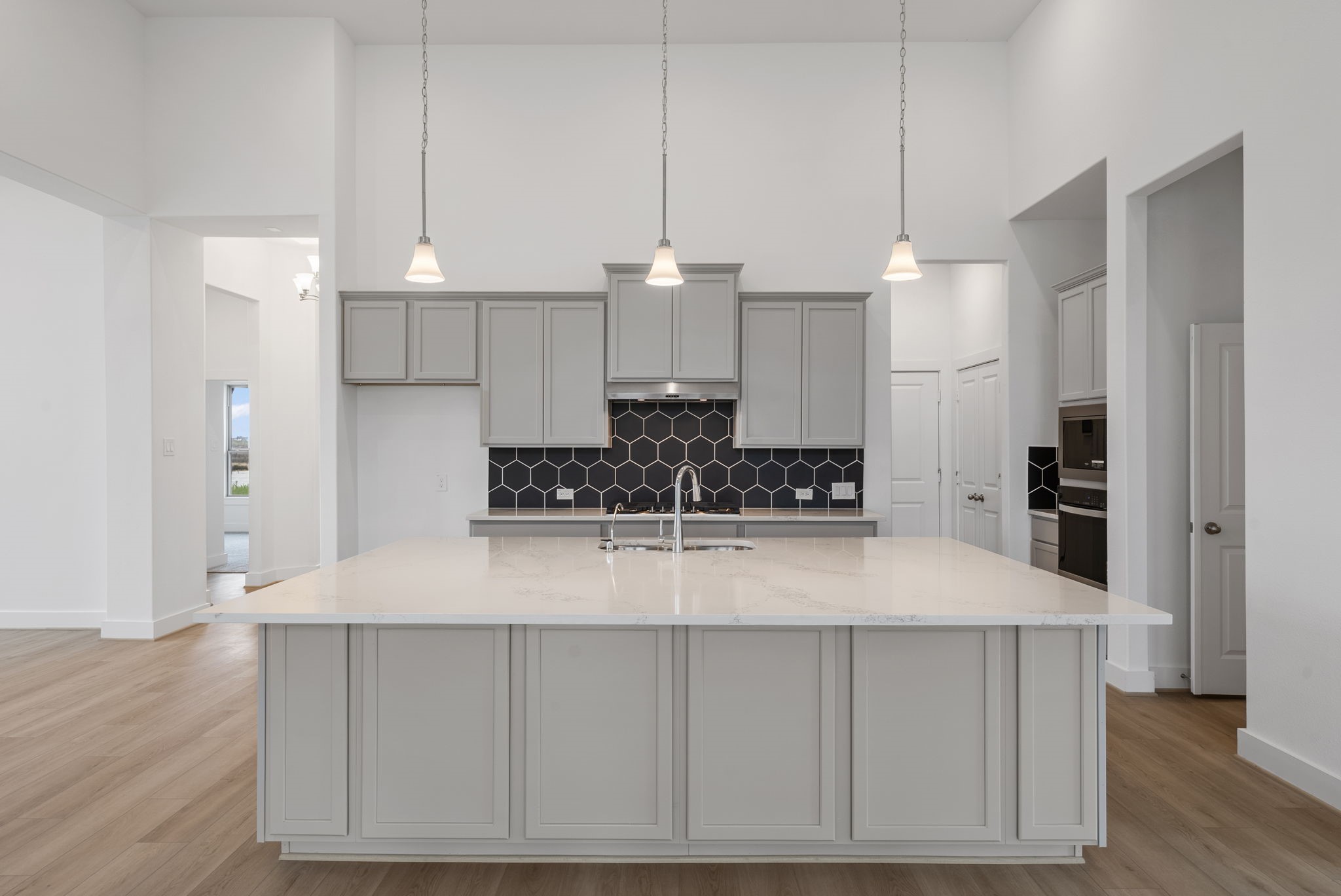 18806 Forested Street Manvel, TX 77578 - Photo 4 of 35 a kitchen with kitchen island granite countertop a stove a refrigerator and a sink with wooden floor