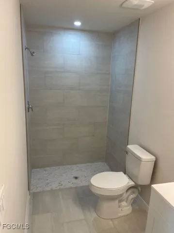 a white toilet sitting next to a shower