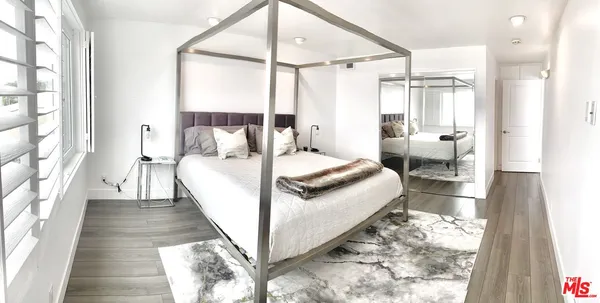 a large white bed sitting in a room next to a window