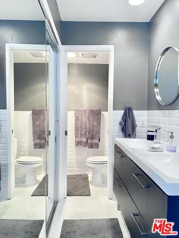 a bathroom with a sink a toilet and a mirror
