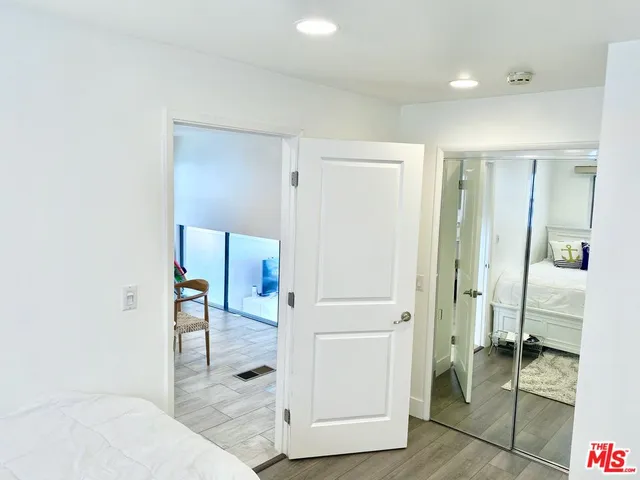 a hallway with white doors wooden floor and front door