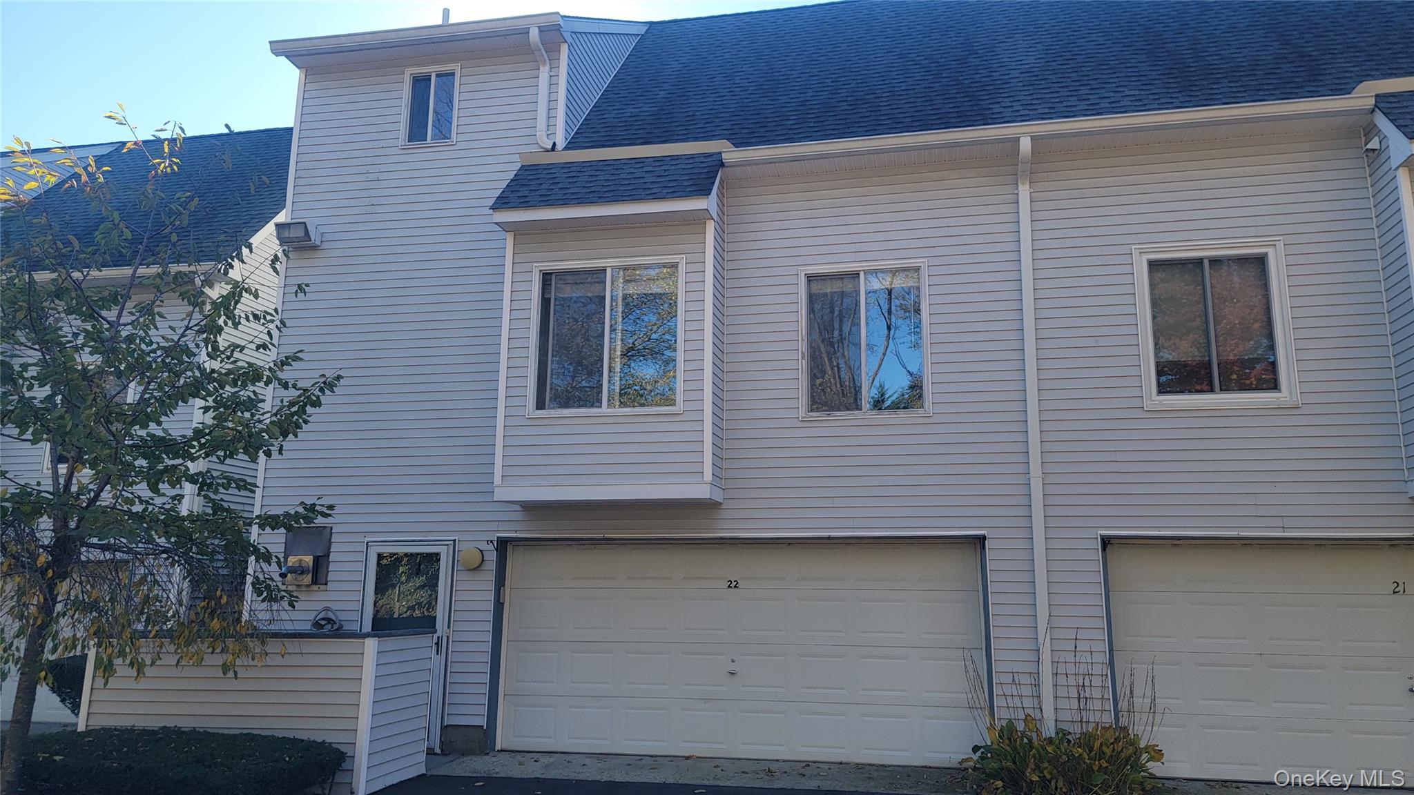 35 Gibbs Road, Unit 22 Coram, NY 11727 - Photo 2 of 20 Back of house with a shingled roof and an attached garage