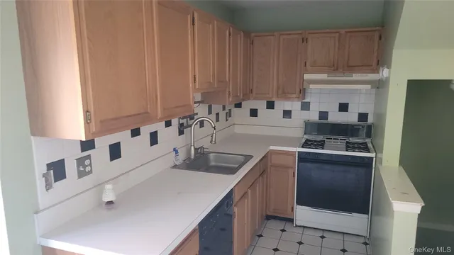 a kitchen with stainless steel appliances a sink a stove a microwave a sink and cabinets