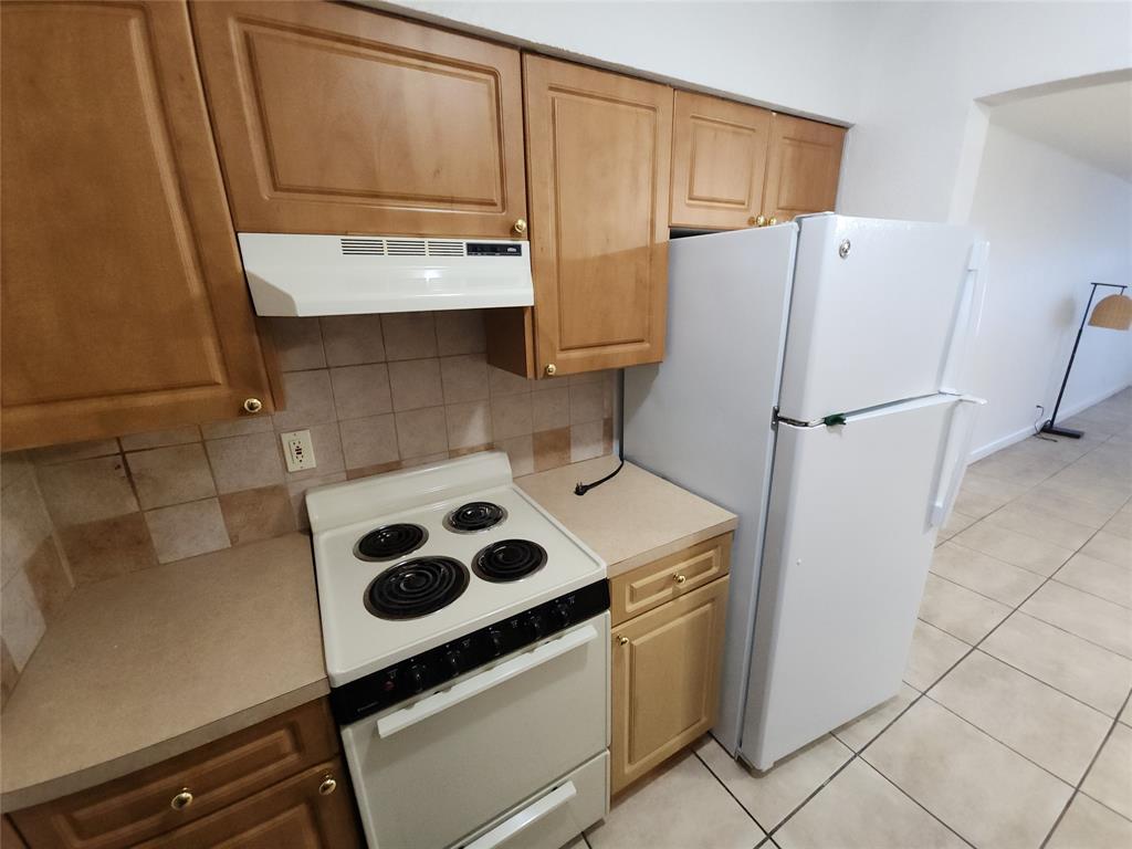 2607 Northeast 8th Avenue, Unit 7 Wilton Manors, FL 33334 - Photo 27 of 30 a kitchen with a refrigerator sink and cabinets