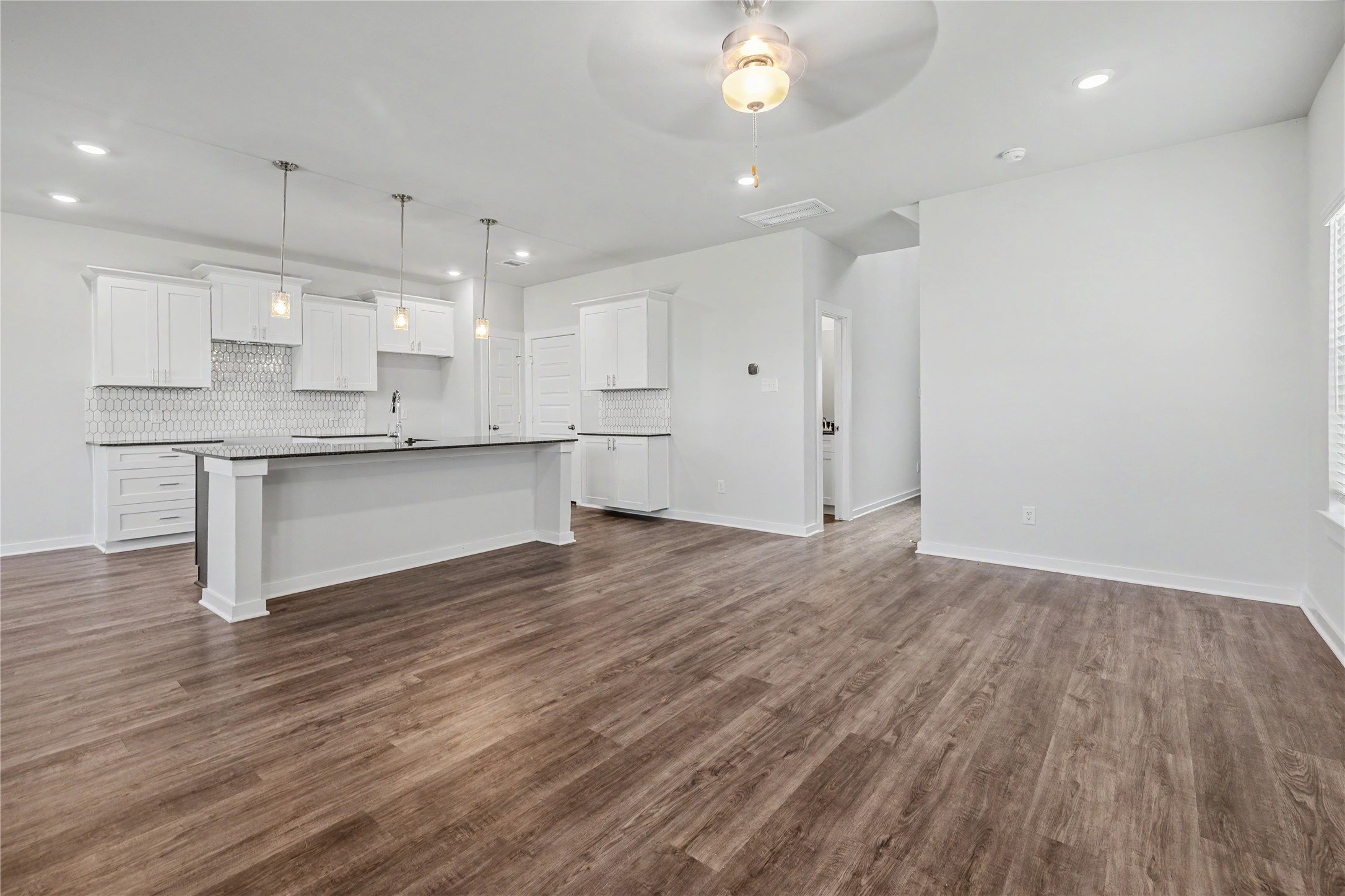 6426 Bolinas Court Rosharon, TX 77583 - Photo 13 of 49 a large kitchen with cabinets wooden floor and stainless steel appliances