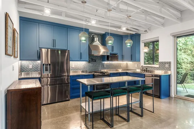 a kitchen with stainless steel appliances granite countertop a sink refrigerator and cabinets