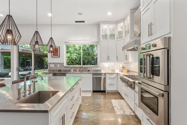 a kitchen with stainless steel appliances granite countertop a sink and stove