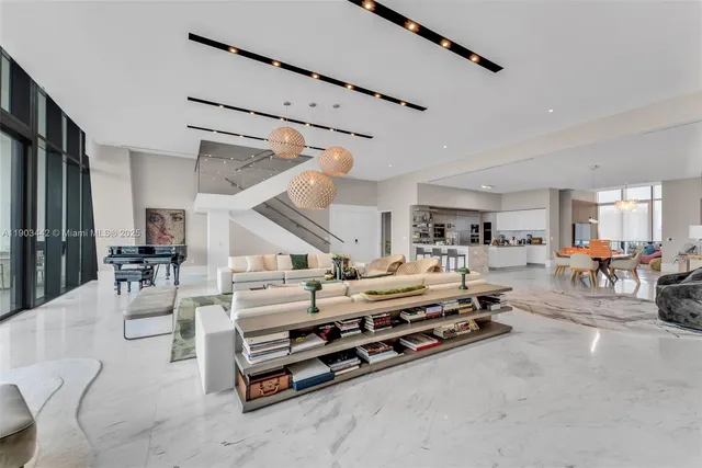 a room with lots of white furniture and couches