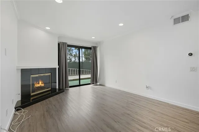 a view of an empty room with a fireplace and a window