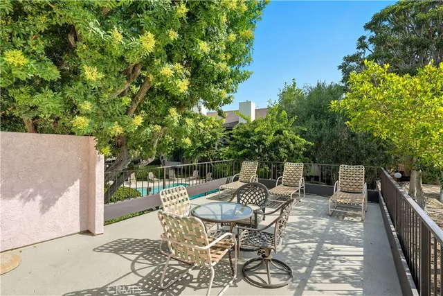 a view of a patio with table and chairs and potted plants with wooden floor and fence