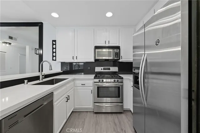 a kitchen with a sink stainless steel appliances and cabinets