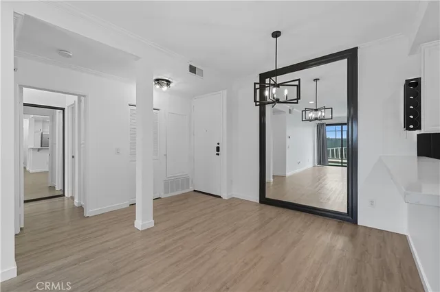 a view of a hallway with wooden floor and stairs
