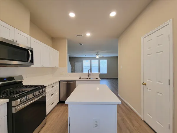 a kitchen with a sink a stove and cabinets