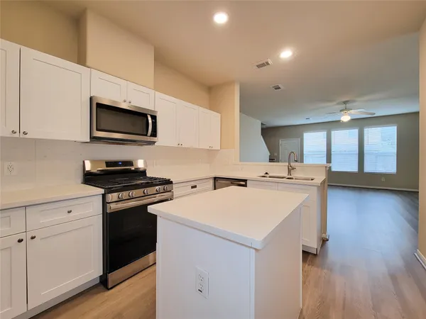 a kitchen with a sink a stove and microwave