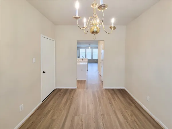 a view of a room with wooden floor and chandelier