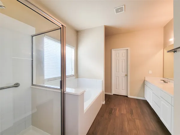 a bathroom with a tub sink and mirror