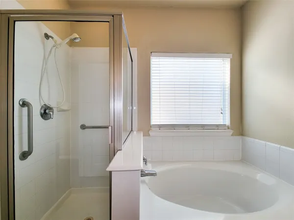 a spacious bathroom with a bathtub shower and sink