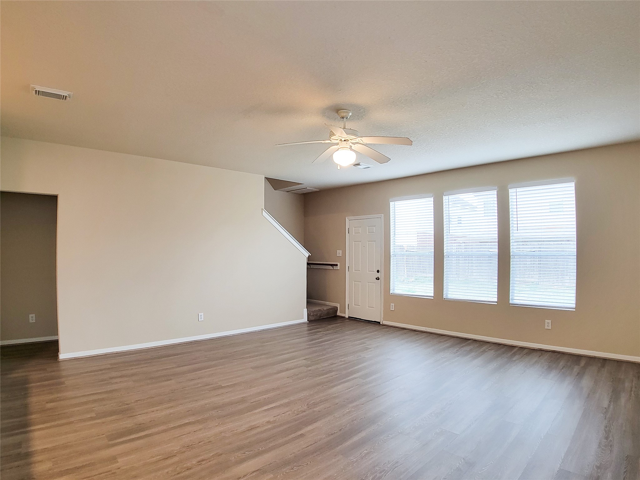 19338 Harvest Stream Way Houston, TX 77084 - Photo 7 of 49 a view of an empty room with wooden floor and a window