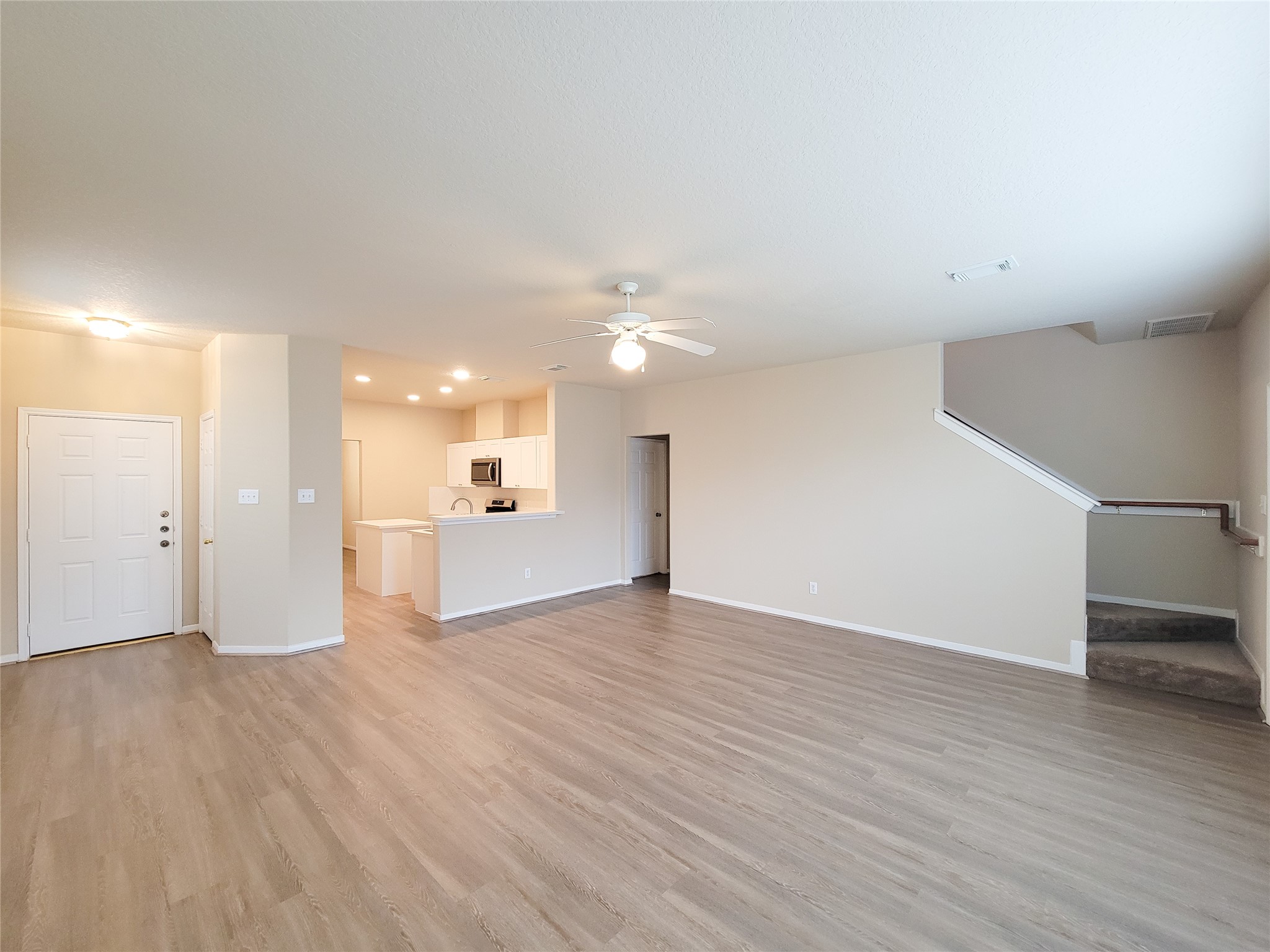 19338 Harvest Stream Way Houston, TX 77084 - Photo 8 of 49 a view of a big room with wooden floor and a kitchen