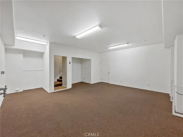 an empty room with closet and windows
