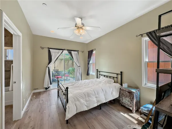 a bedroom with a bed a dresser and wooden floor