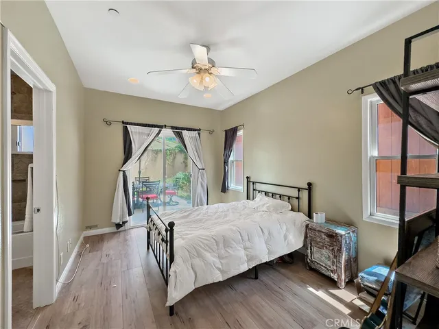 a bedroom with a bed a dresser and wooden floor