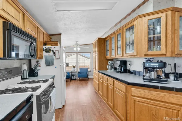 a kitchen with stainless steel appliances granite countertop a stove top oven a sink dishwasher a microwave oven and a dining table with wooden cabinet