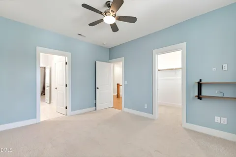 a view of an empty room with wooden floor and closet