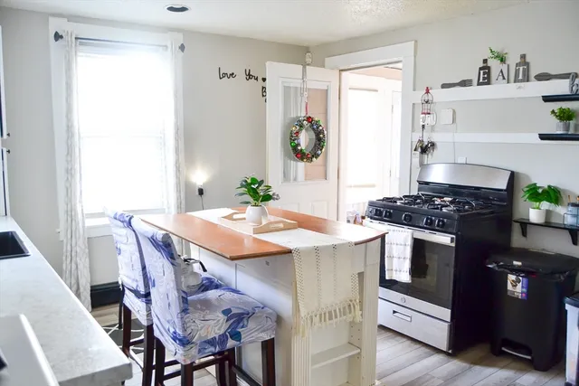 a kitchen with stainless steel appliances kitchen island a table and chairs in it