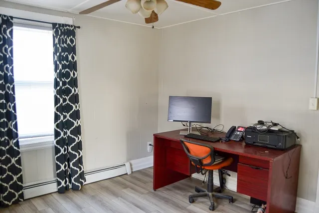 a view of a workspace with furniture and a window