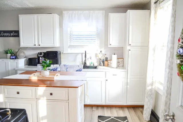 a kitchen with granite countertop white cabinets and white appliances