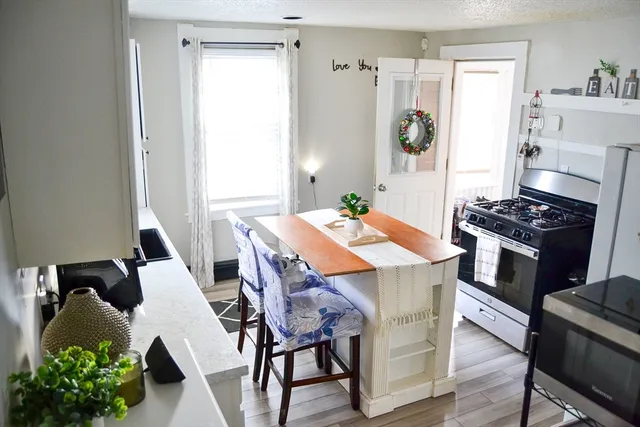 a kitchen with stainless steel appliances kitchen island a table and chairs in it