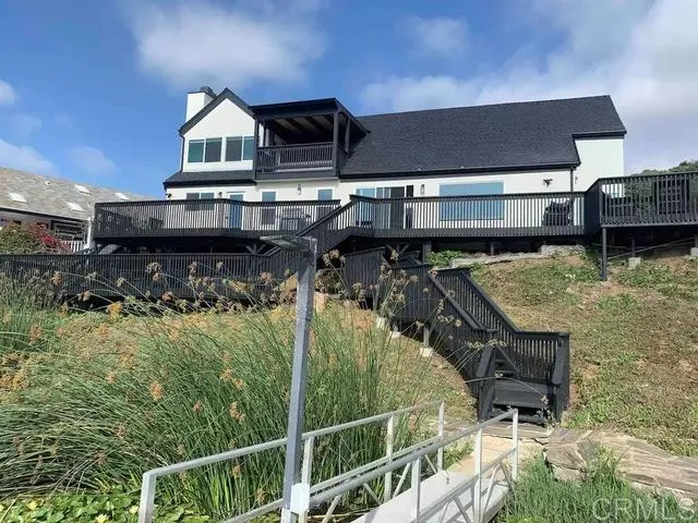 a view of house with roof deck and seating space