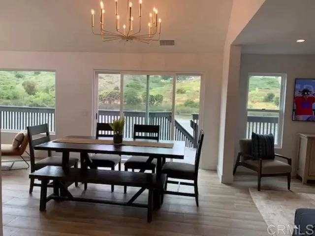 a dining room with furniture a chandelier and wooden floor