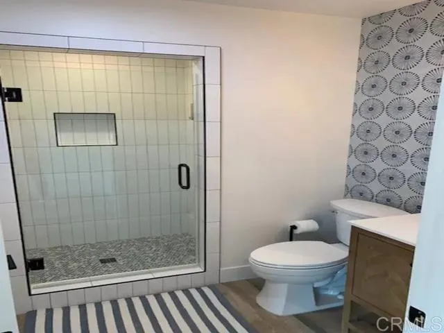 a bathroom with a toilet and a shower