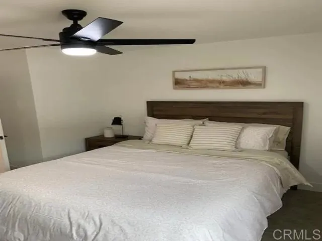 a bedroom with a bed and a ceiling fan