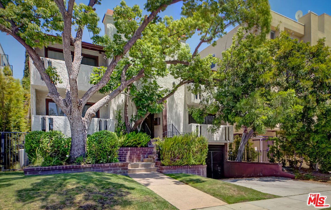 a view of a house with a tree in front of it