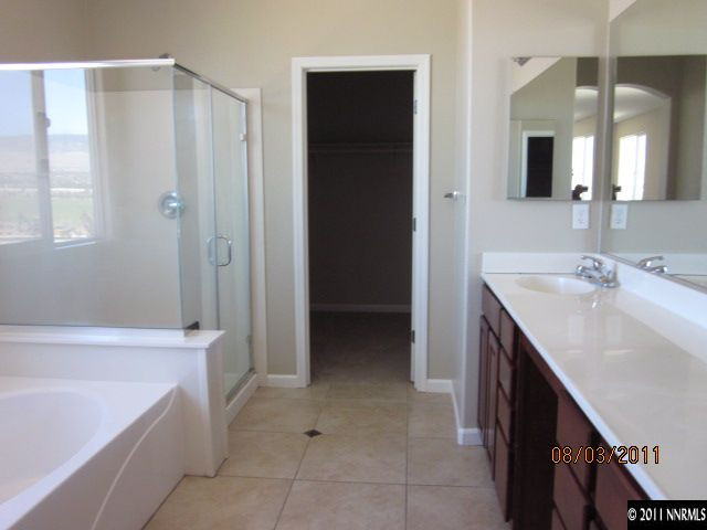 11109 Messina Way Reno, NV 89521 - Photo 8 of 11 a spacious bathroom with a bathtub sink and mirror