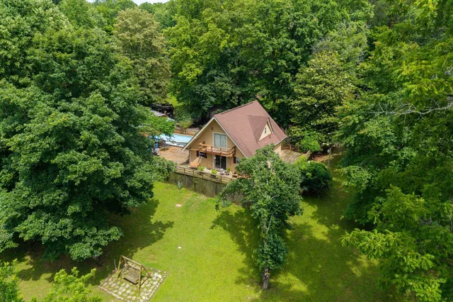 an aerial view of a house with swimming pool and garden