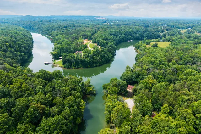 an aerial view of a house with a yard and lake view