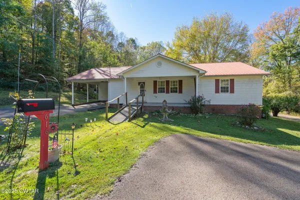 a view of a house with a yard and sitting area