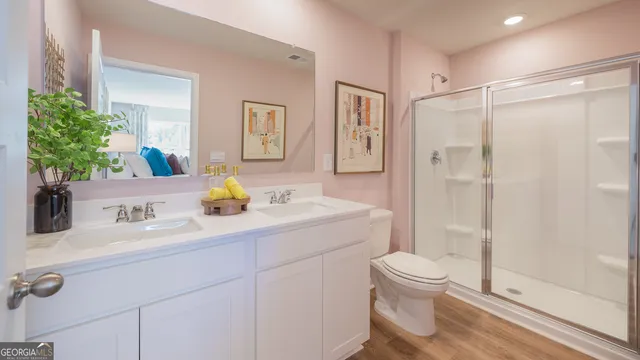 a bathroom with a double vanity sink toilet and shower