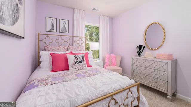 a bedroom with a bed a dresser with wooden floor