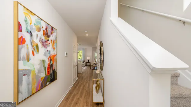 a view of a hallway with wooden floor and staircase