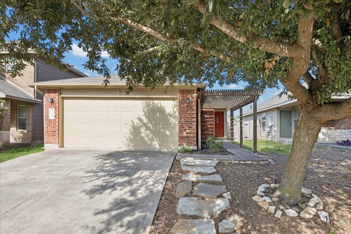 a front view of a house with a garden and trees