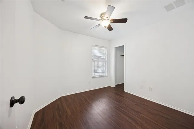 wooden floor in an empty room with a window