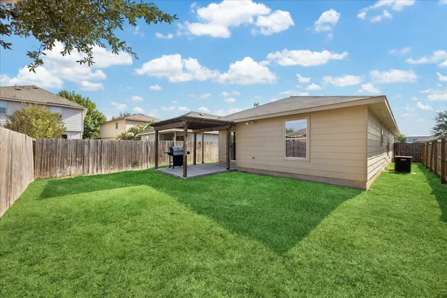 a view of a house with a yard and large tree