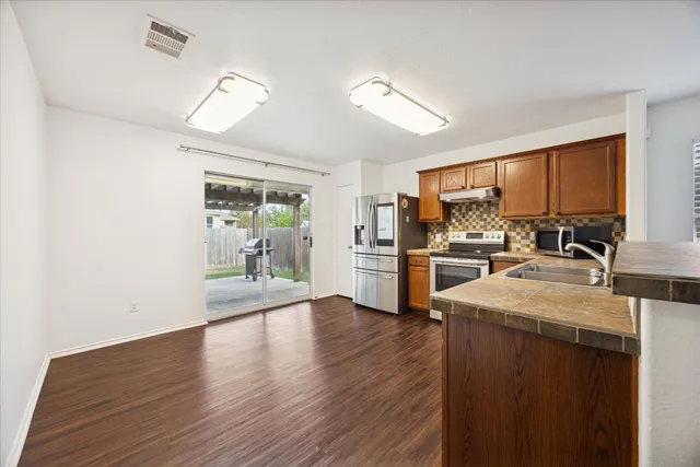 a kitchen with a refrigerator and a stove top oven