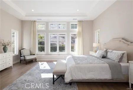 a bedroom with a bed couch and windows